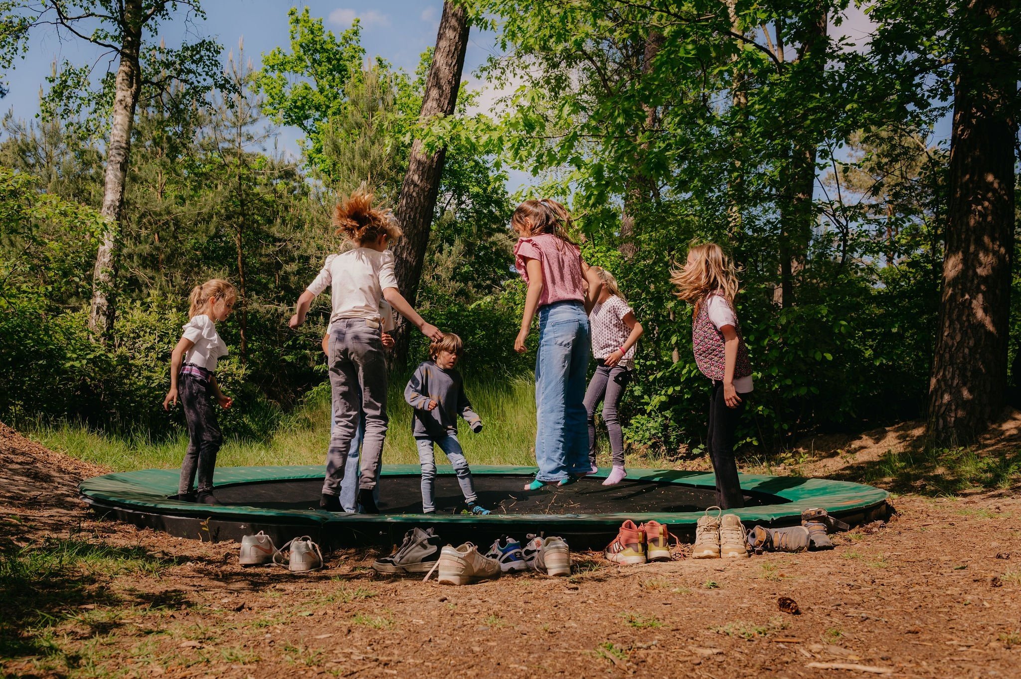 Kinderen die springen op trampoline op Bospark De Vossenberg op de Veluwe.